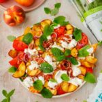 Sałatka z grillowanymi brzoskwiniami, pomidorami, szynką parmeńską, pistacjami, mięta i melisą